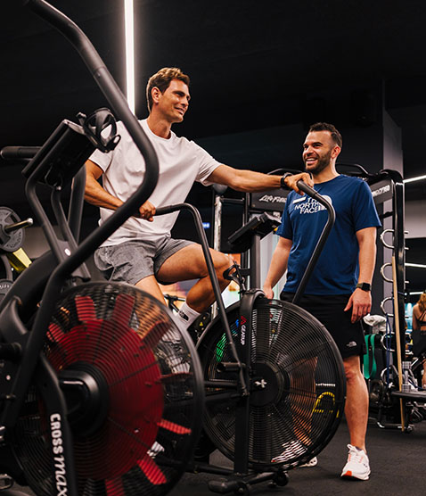 Holmes Place | άντρας που κάνει στατικό ποδήλατο στο γυμναστήριο